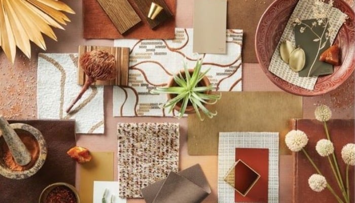 Various materials and colors displayed on a table, including fabrics, papers, and paints
